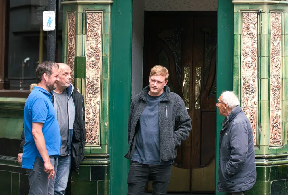 Mensen voor de deur van pub Beehive